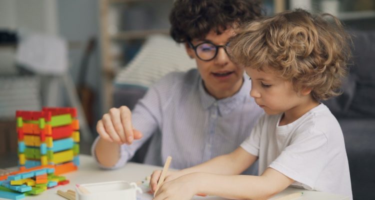 a man and a child are playing with blocks